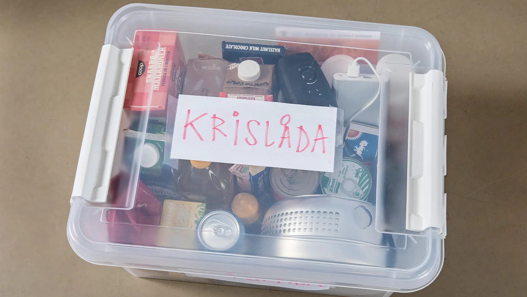 Plastlåda med konserver, stormkök, tändstickor och annat som behövs i en krislåda.